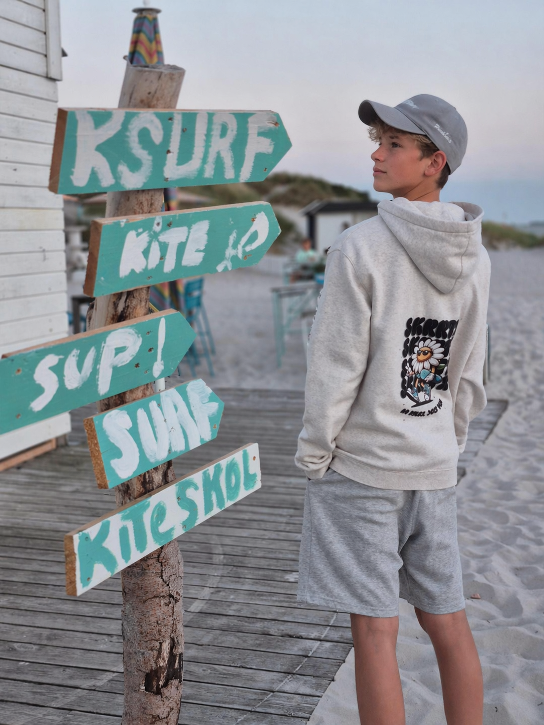 Model in SKRRTX hoodie in front of a red and yellow lifeguard tower